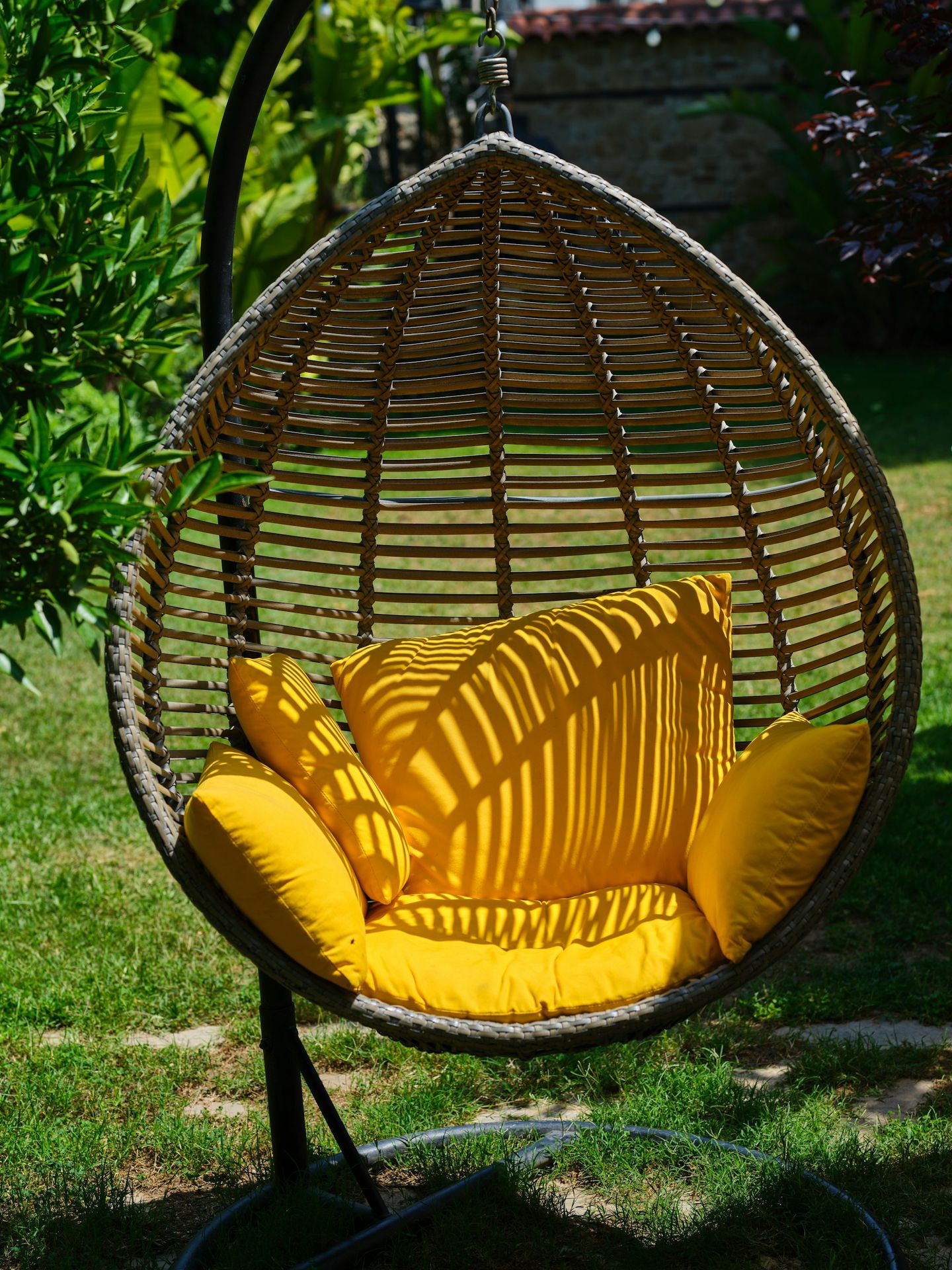 a swing chair with a yellow pillow on it